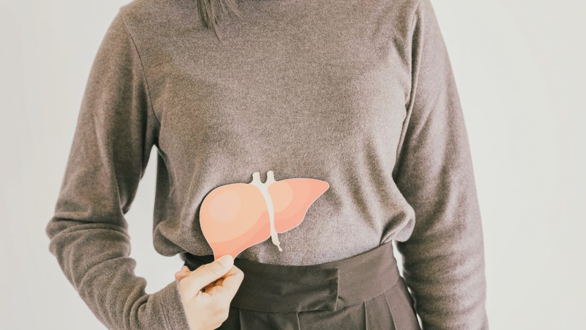 woman holding a cut out of a liver in front of her body indicating fatty liver