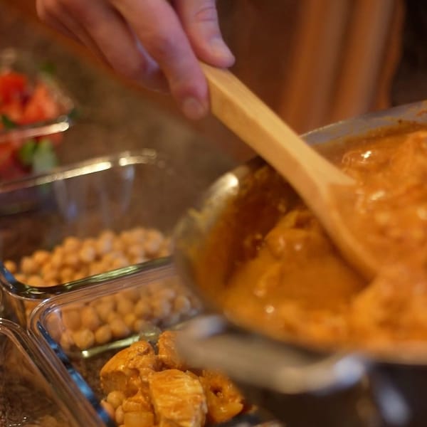 Portioning a chickpea curry into meal-prep containers