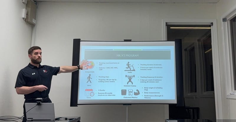 Kevin pointing to the program steps on a presentation slide